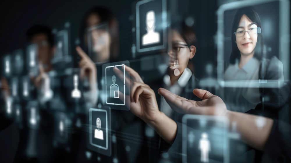 People interact with virtual profile icons and digital images on a transparent touchscreen interface, highlighting a modern tech recruitment Singapore experience in digital networking.